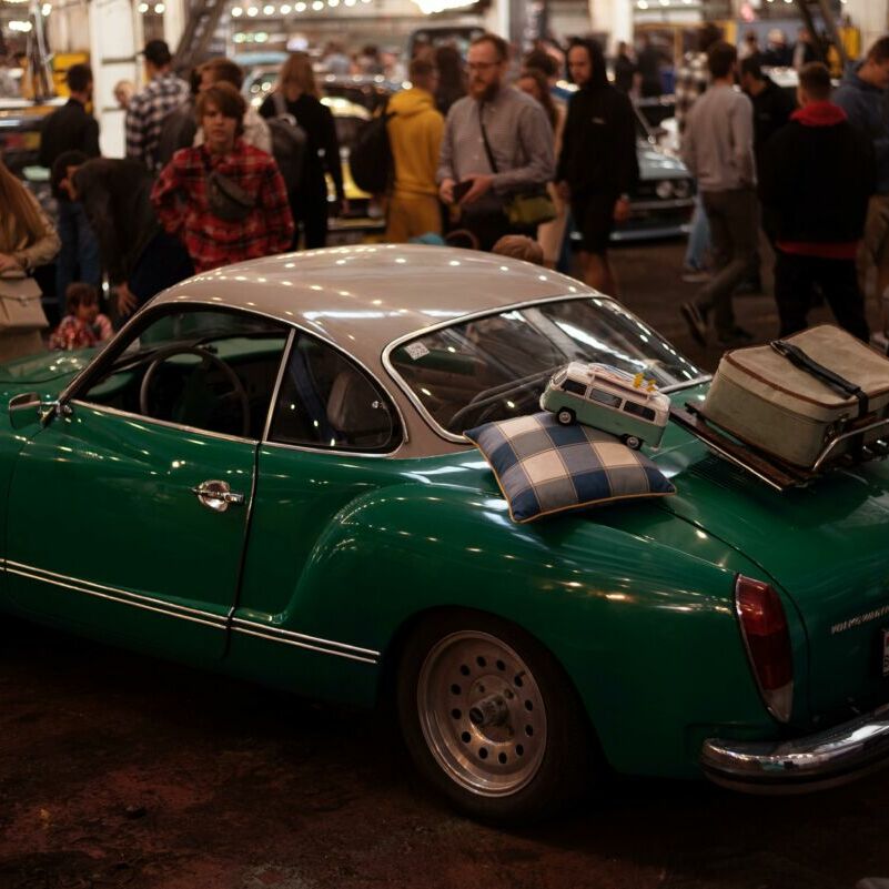 Classic Volkswagen at a bustling car exhibition, evoking nostalgia.
